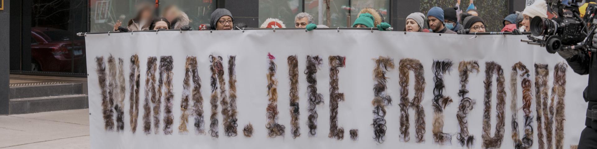 Demonstrators hold Woman, Life, Freedom sign in Toronto