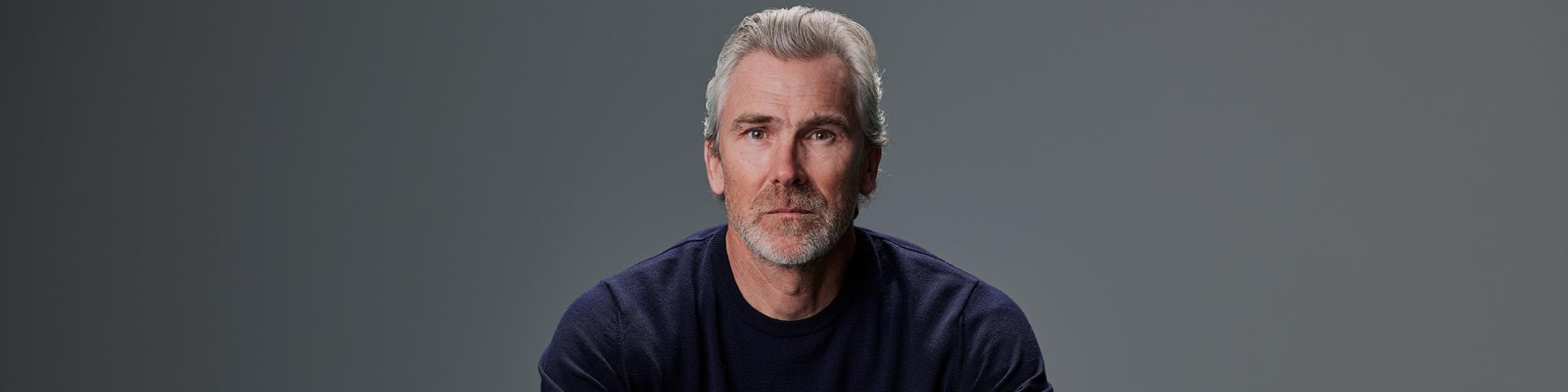 Trevor Linden in a grey chair 