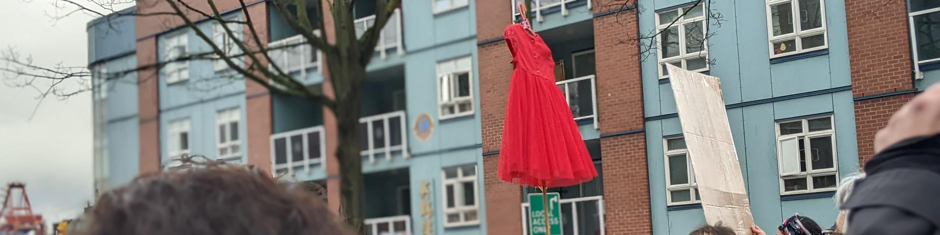 Women's Memorial March 2022 - photo of people marching holding up a red dress