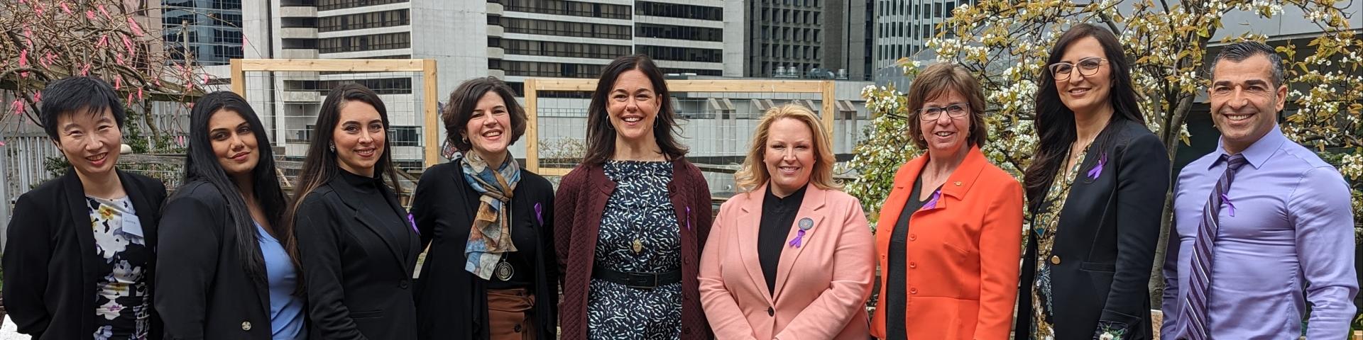 Axis program managers and facilitators stand with YWCA CEO and BC government ministers to celerb