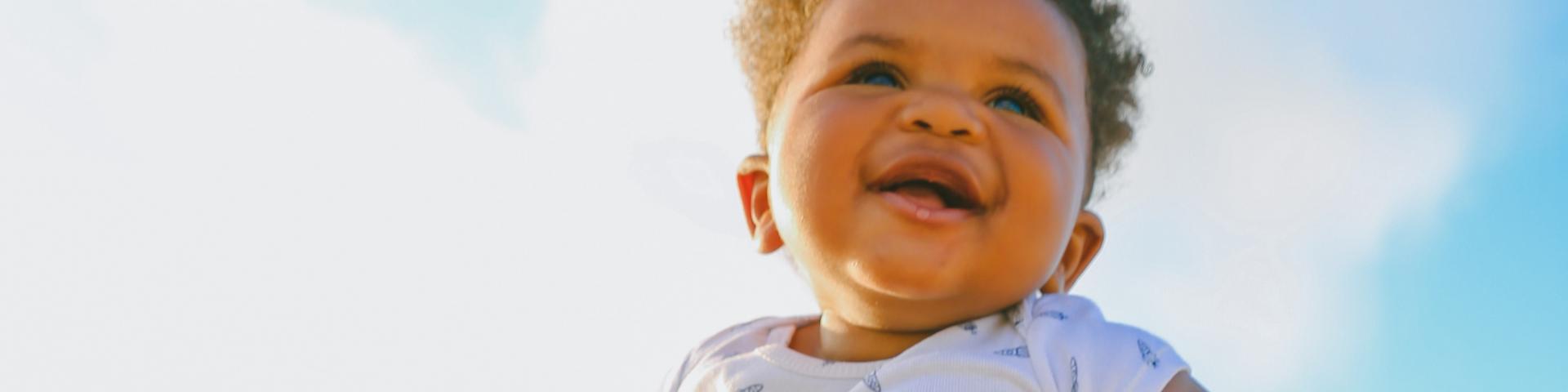 Woman holding little baby up 