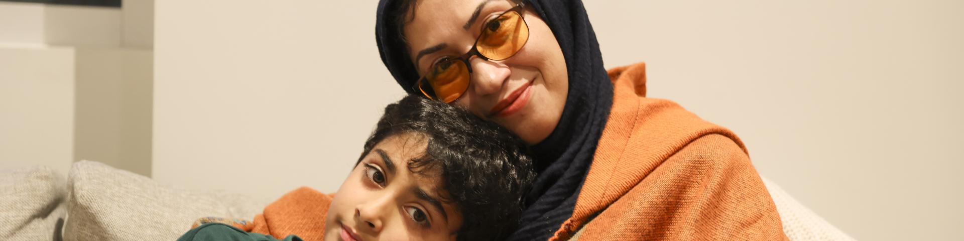 Son leaning on his mother for support