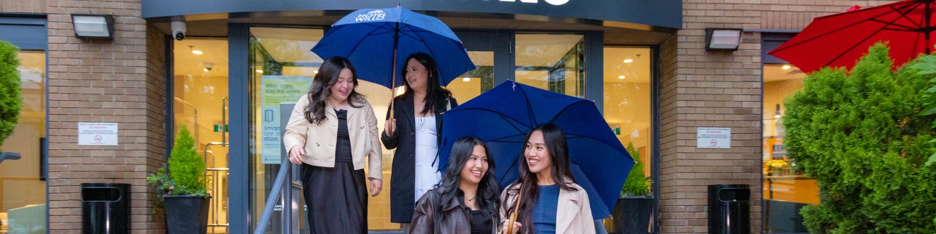 Four ladies leaving YWCA's hotel front entrance 