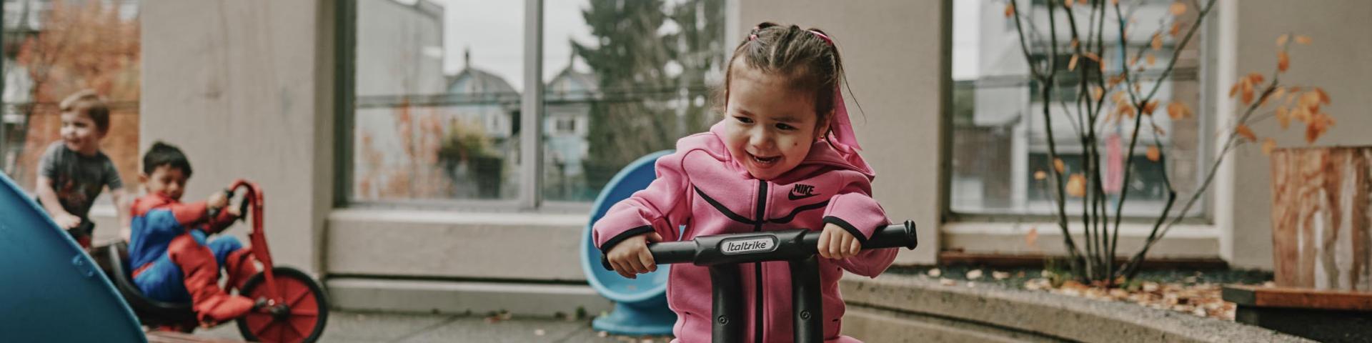 A child riding their bike around the child care centre's playground