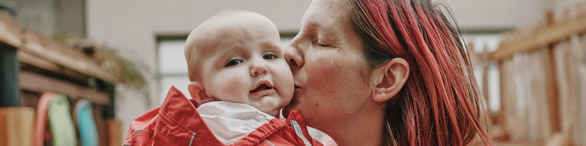 Mom kissing baby
