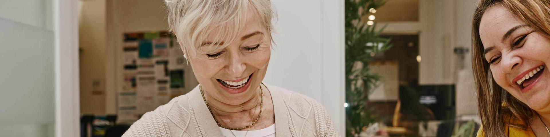 YWCA Career Advisor and Mentos smiling and reviewing a resume