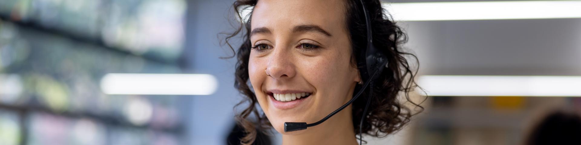 Happy customer service representative using a headset while working at a call center