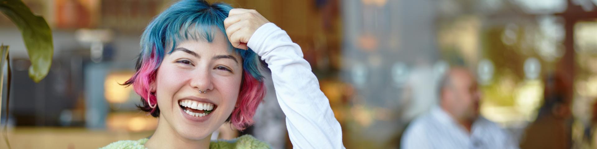 Smiling young woman with colorful hair.