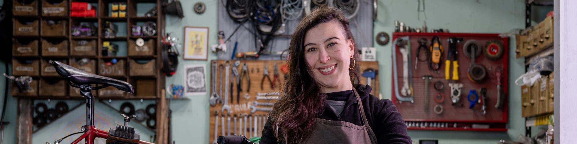 Bike mechanic in a room full of tools and a bike frame