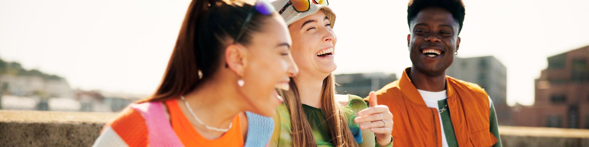 Group of young adults in colorful clothes laughing
