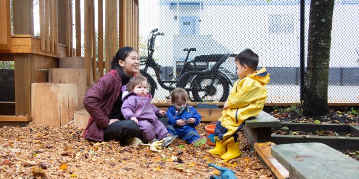 Early childhood educator with two children on playground