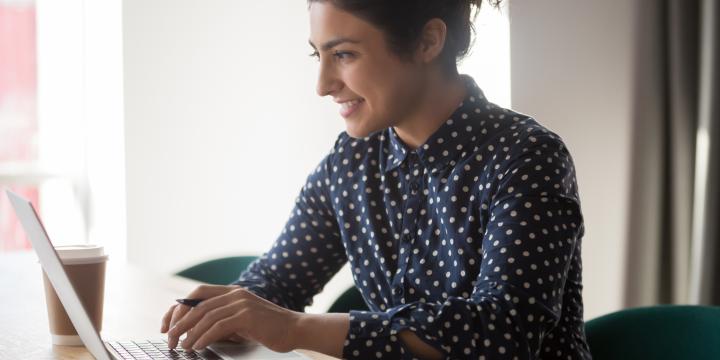 Indian women with a navy blue shirt working on a laptop 