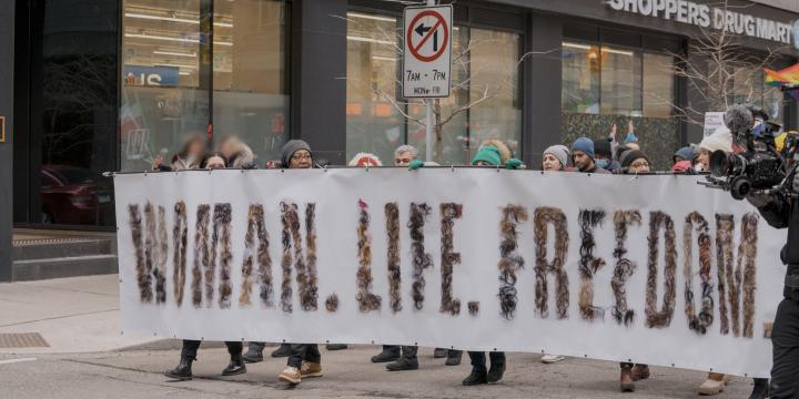 Demonstrators hold Woman, Life, Freedom sign in Toronto