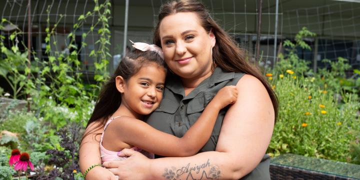 Mom and daughter hugging outside 