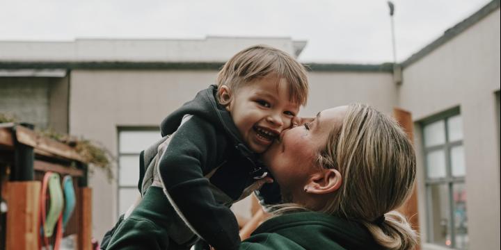 Mother kissing child 