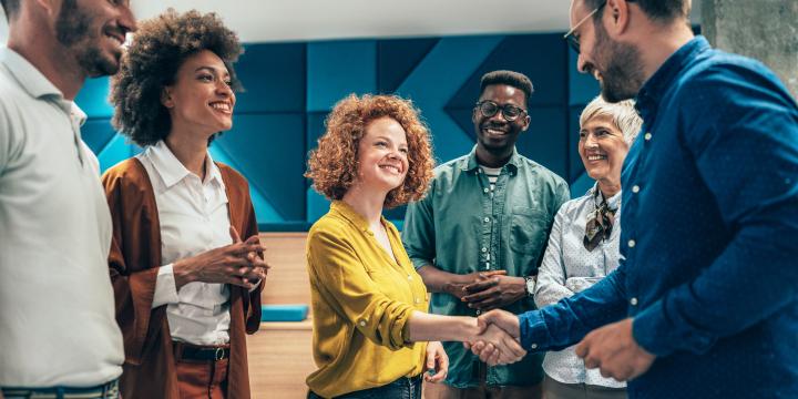 Happy businesswoman shaking hands with her colleague on a meeting in the office.