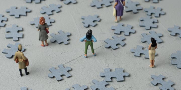 Woman figures looking at scattered puzzle pieces