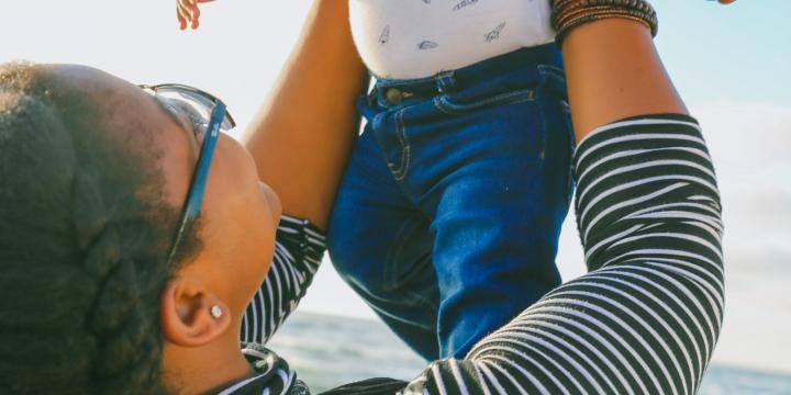 Woman holding little baby up 