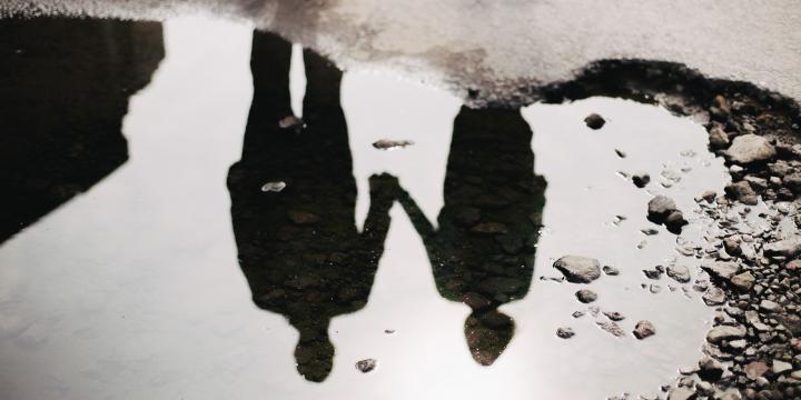 Two people standing and holding hands