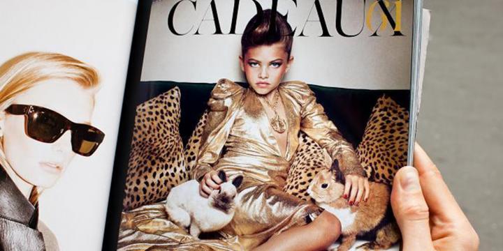 Hand holding a magazine showing an underage model 