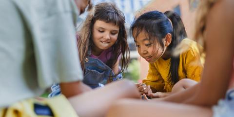 Children of different ethnicity sitting down talking