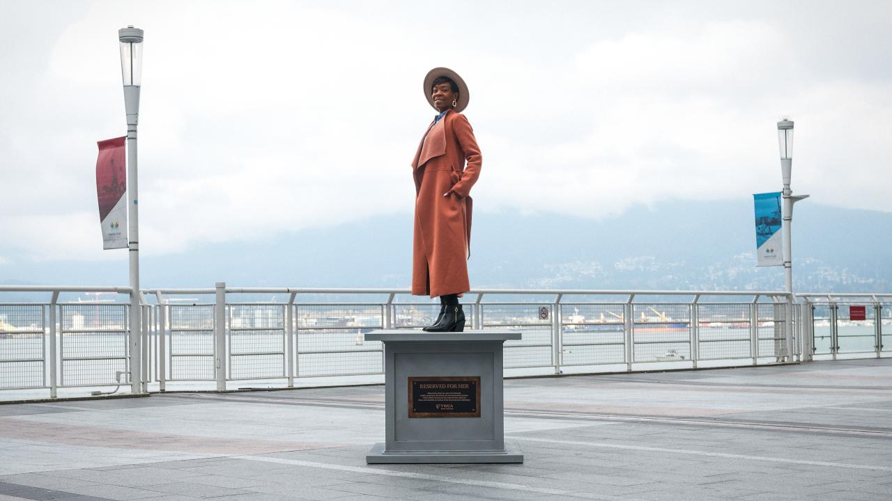 woman posing on statue base