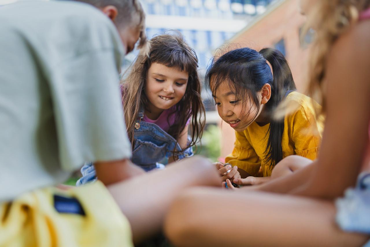 Children of different ethnicity sitting down talking
