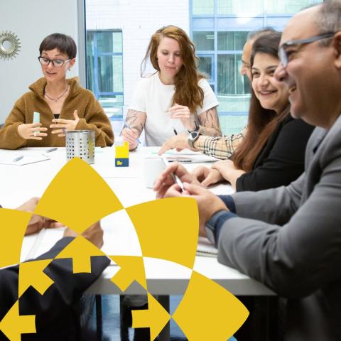 Diverse group of people in business casual wear sitting around a table