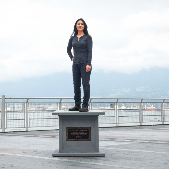 woman posing on statue base