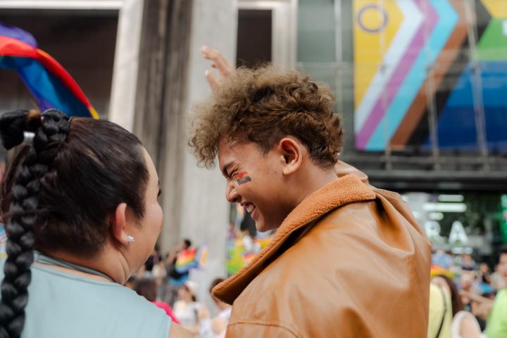 Two people smiling and enjoying the pride parade