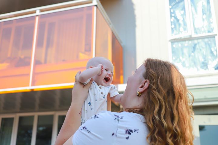 YWCA participant holding a laughing baby up