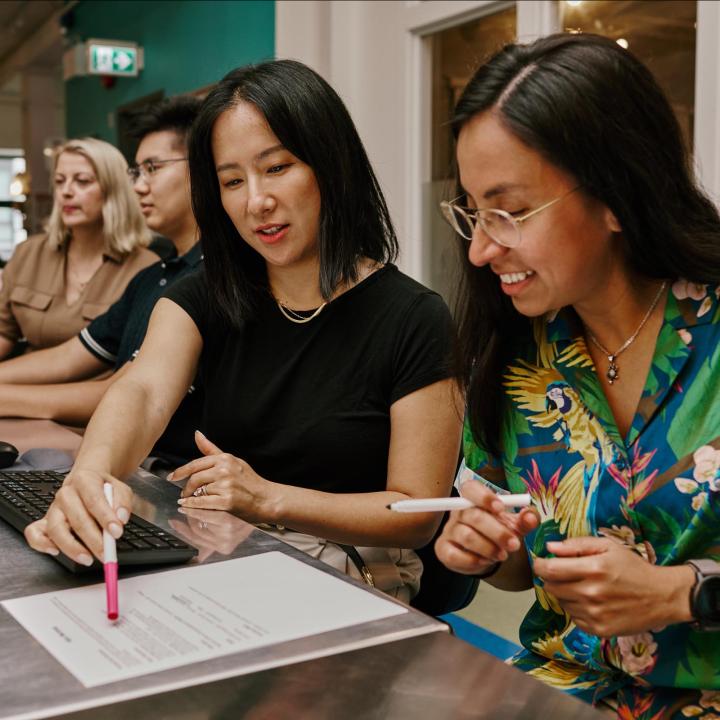 Two women looking at a resume
