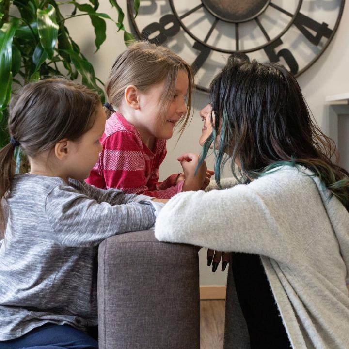 Mother and two children looking at each other in a living quarters