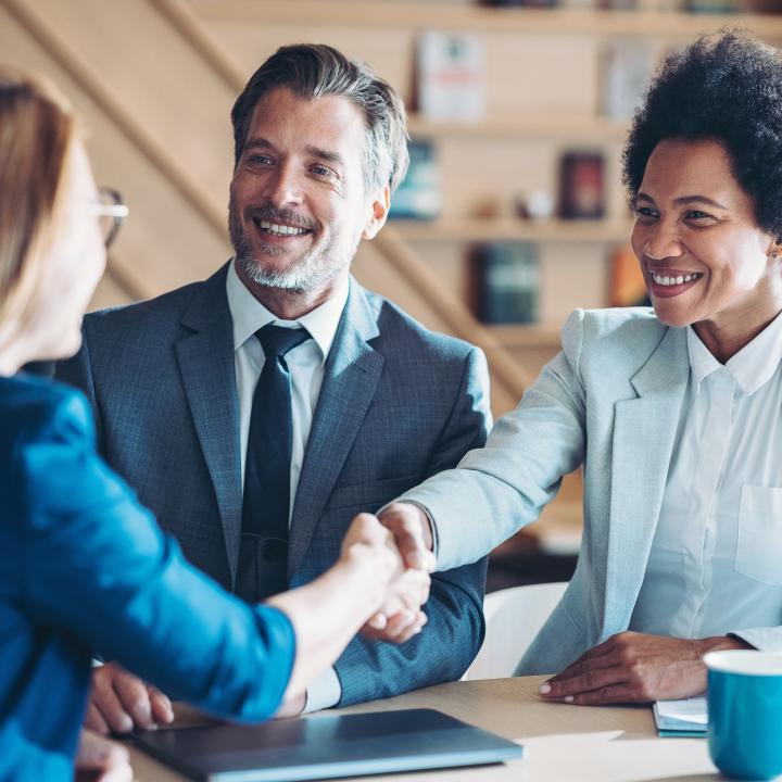 Financial planer shakes hand with clients