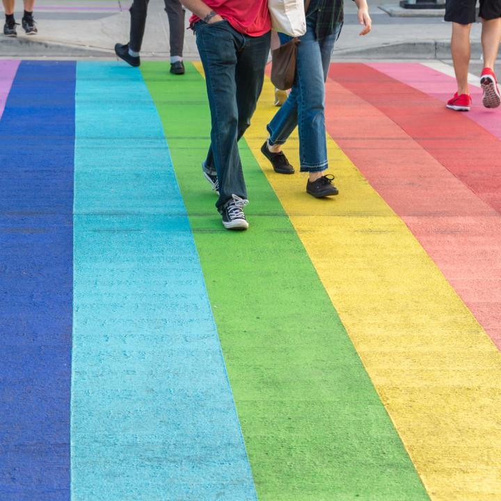 People crossing rainbow crosswalk